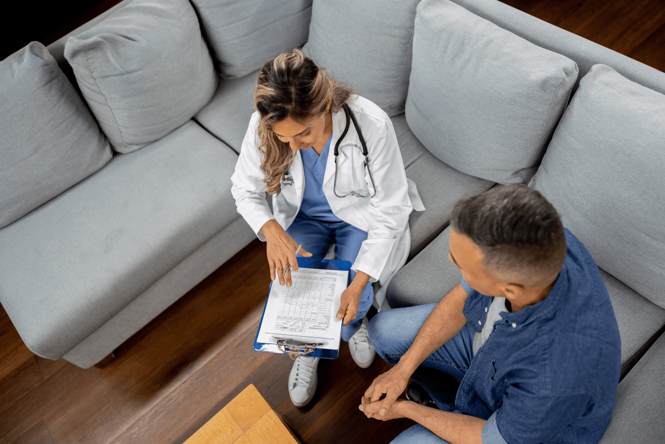 Doctor discussing health information with a patient in a living room.